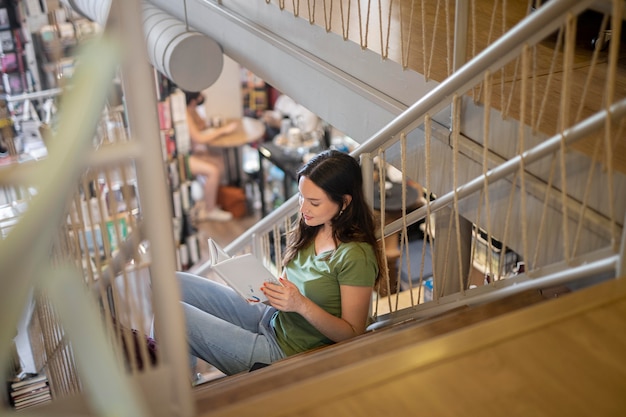 Free photo full shot student learning on stairs