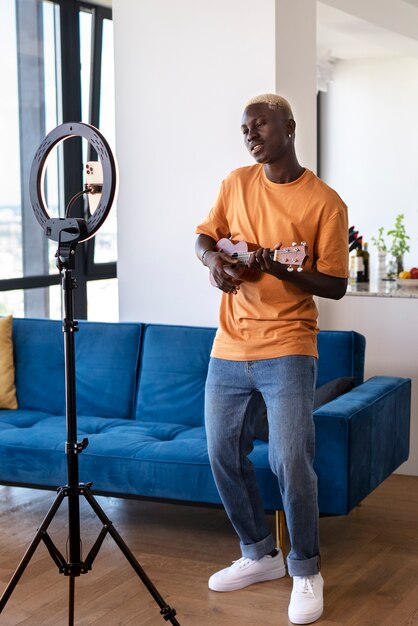 Full shot teen playing the ukulele