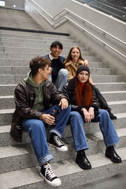 Full shot teens sitting on stairs