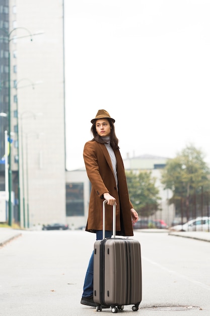 Full shot traveler with coat and hat