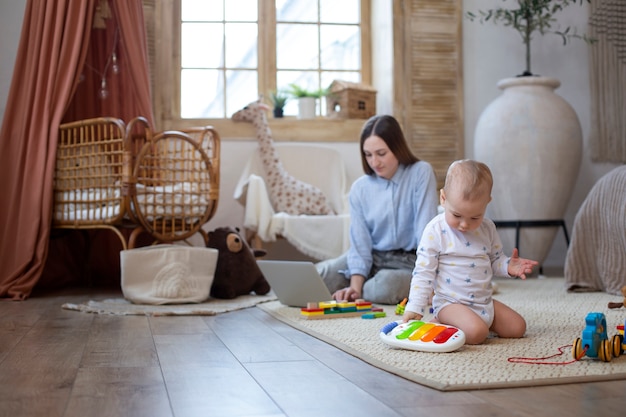 Full shot woman and baby on floor