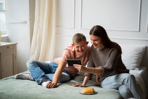 Full shot woman and boy with smartphone