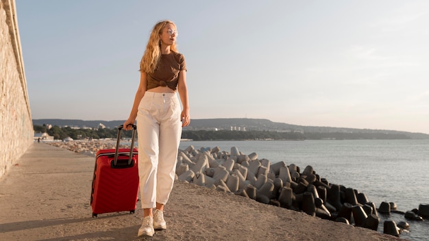 Free photo full shot woman carrying luggage