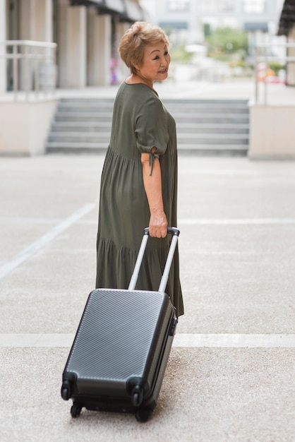 Full shot woman carrying luggage