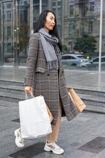 Full shot woman carrying shopping bags