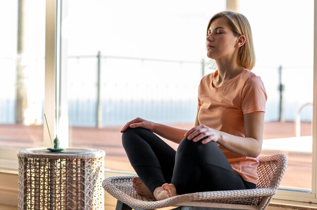 Full shot woman on chair meditating