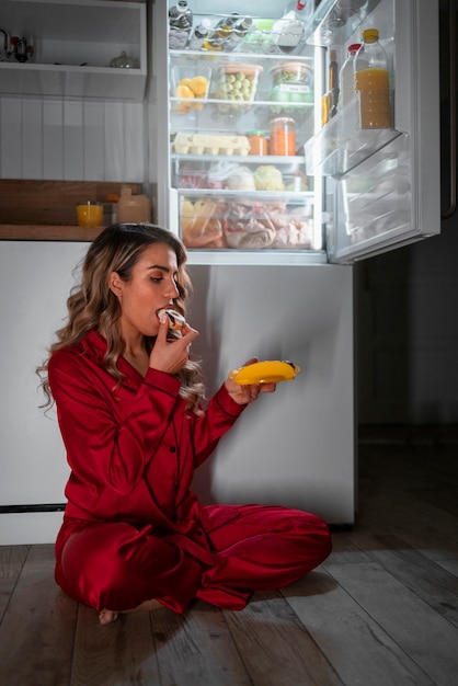 Free Photo full shot woman checking fridge at night