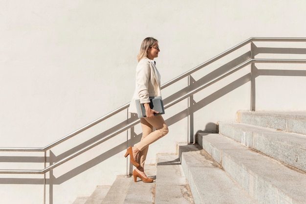 Full shot woman climbing up stairs