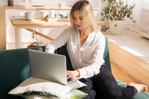 Free photo full shot woman on couch working