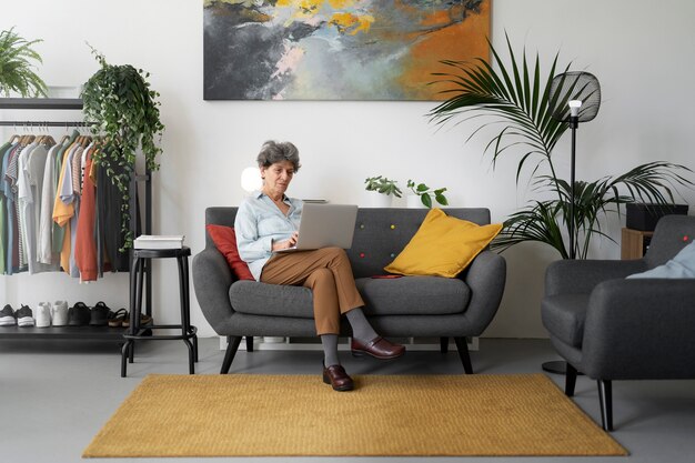 Full shot woman on couch working