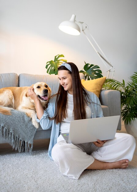 Full shot woman and cute dog at home