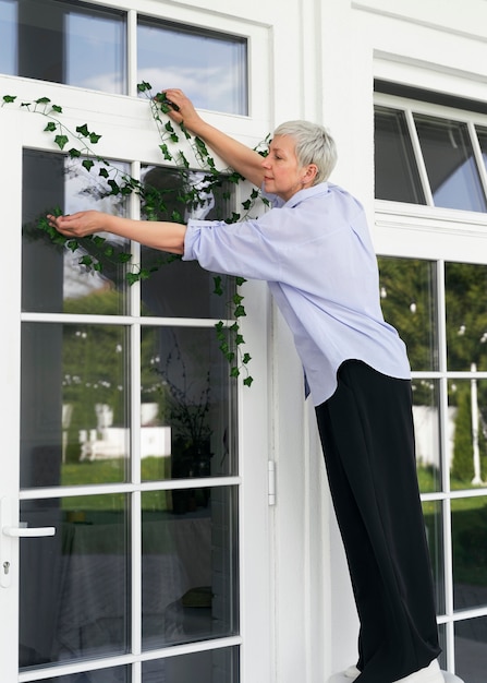 Free Photo full shot woman decorating front door outside