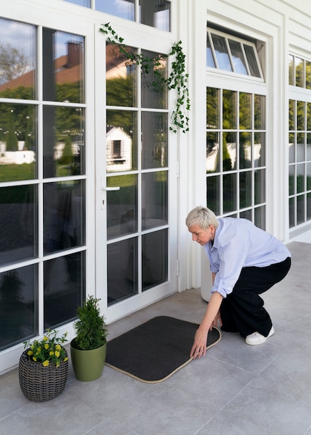 Free photo full shot woman decorating front door outside