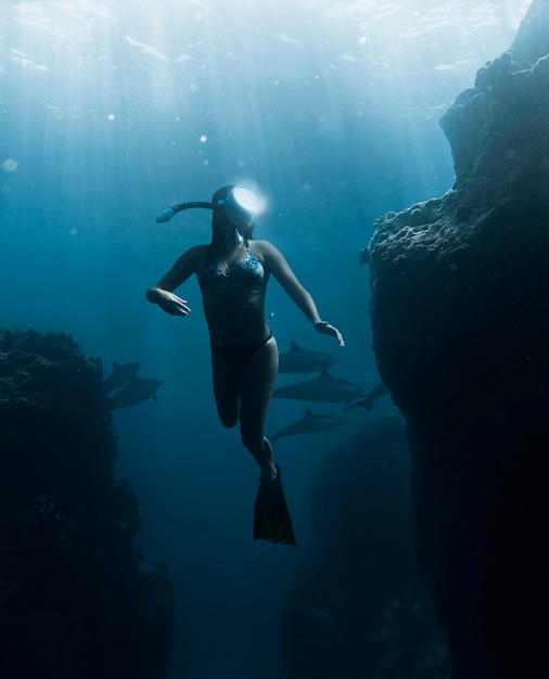 Full shot woman diving with equipment