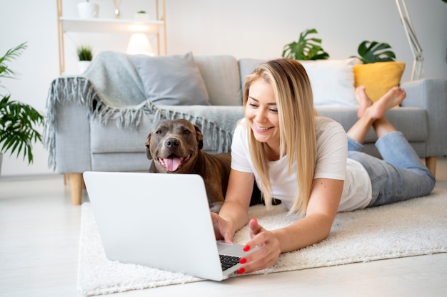 Full shot woman and dog on floor