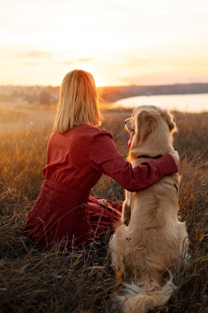 Free Photo full shot woman and dog at sunset