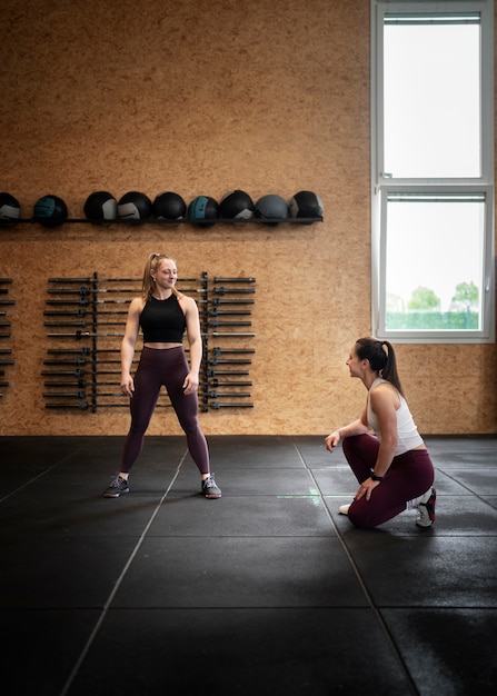 Full shot woman doing burpees at gym