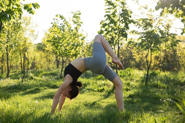 Full shot woman doing yoga in nature