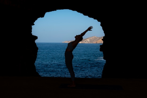 Free photo full shot woman doing yoga pose outdoors