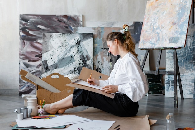 Full shot woman drawing on floor