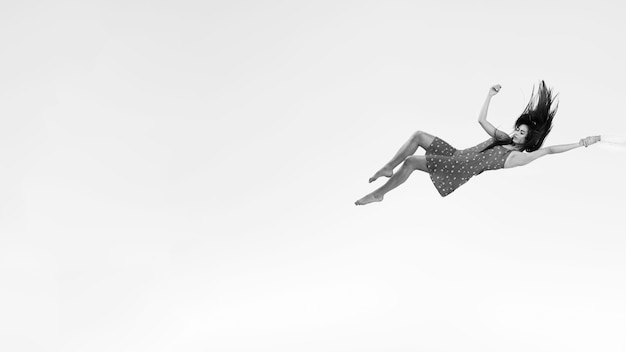 Free Photo full shot woman in dress floating grayscale