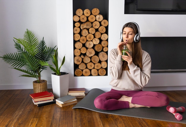 Full shot woman drinking smoothie