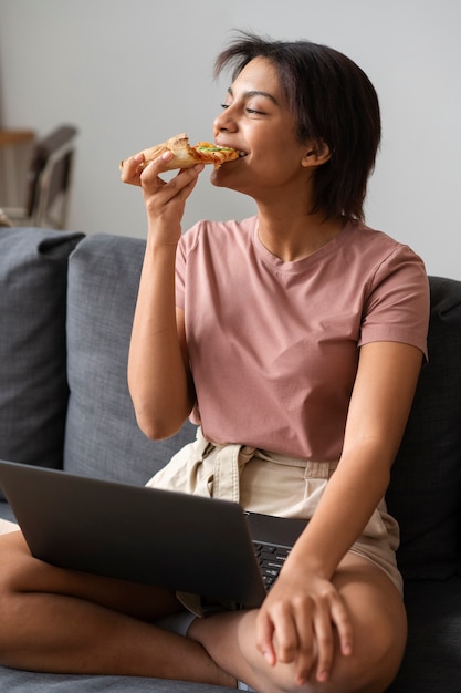 Full shot woman eating delicious pizza