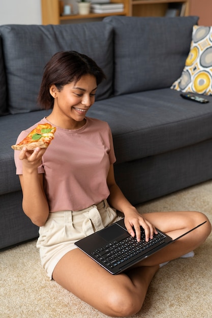 Full shot woman eating delicious pizza