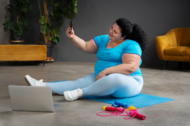 Free photo full shot woman exercising at gym