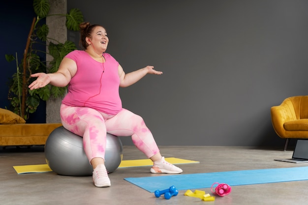 Full shot woman exercising at gym