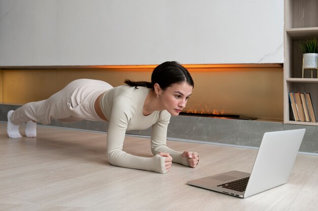 Full shot woman exercising indoors