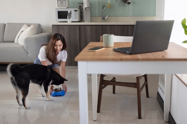 Full shot woman feeding dog