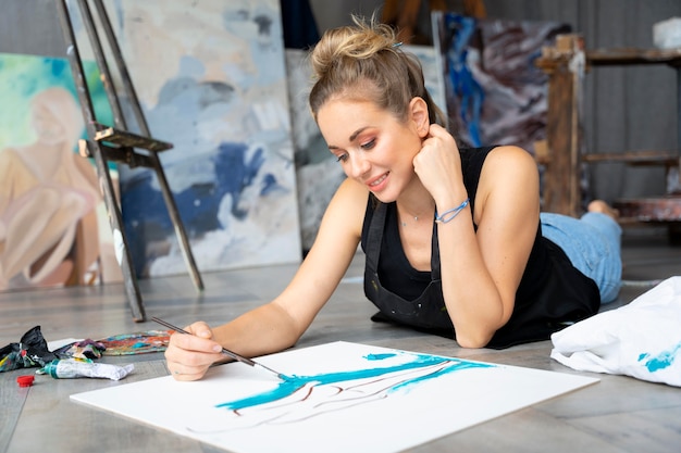 Full shot woman on floor painting