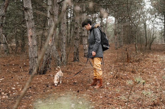 Free photo full shot woman in forest with cute dog