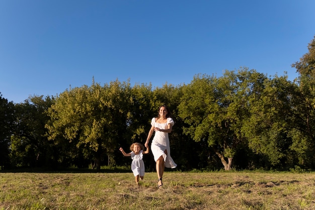 Full shot woman and girl outdoors