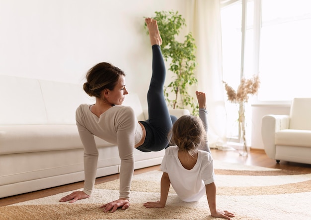 Full shot woman and girl working out indoors