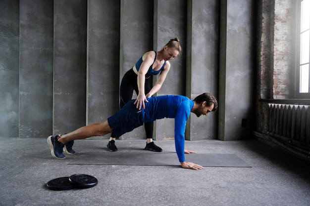 Free photo full shot woman helping man work out