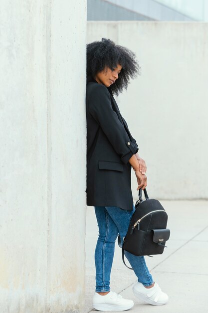 Full shot woman holding backpack