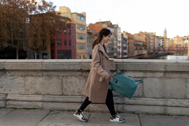 Full shot woman holding backpack