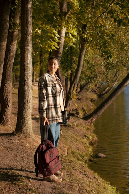 Free photo full shot woman holding backpack