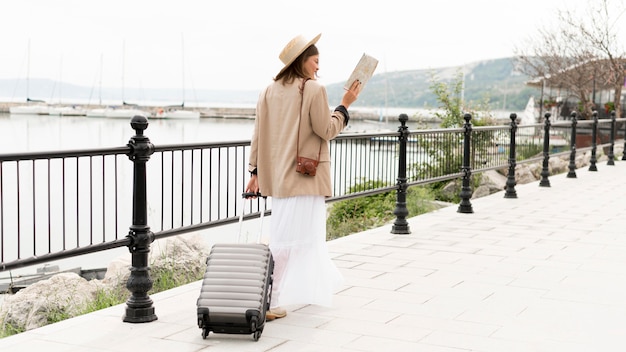 Free photo full shot woman holding baggage