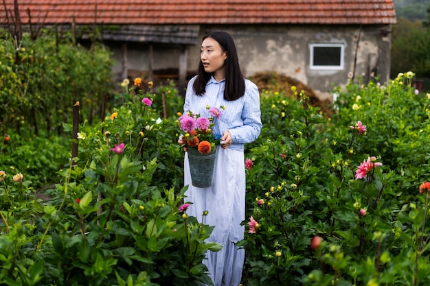 Free photo full shot woman holding beautiful flowers