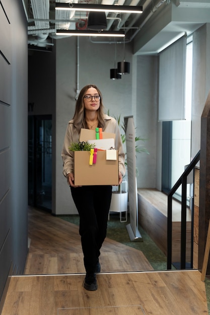 Full shot woman holding cardboard box