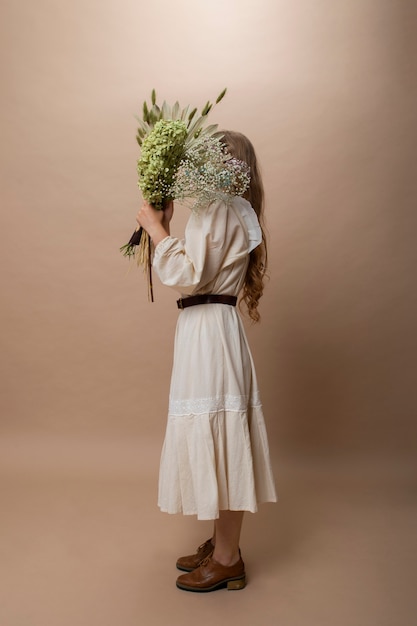 Full shot woman holding dried plants