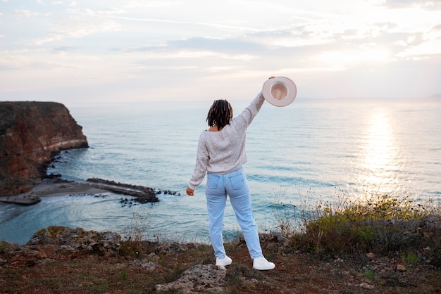 Free photo full shot woman holding hat