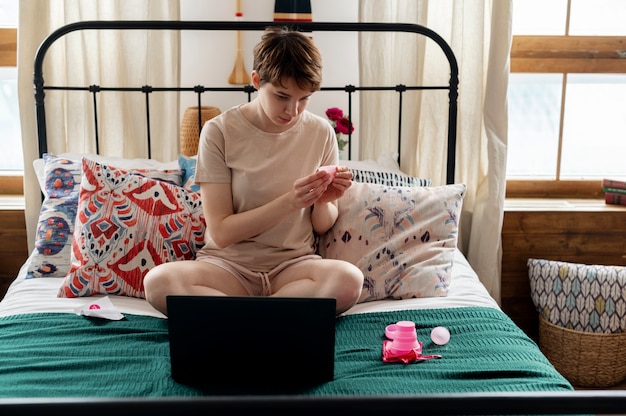 Full shot woman holding pink menstrual cup