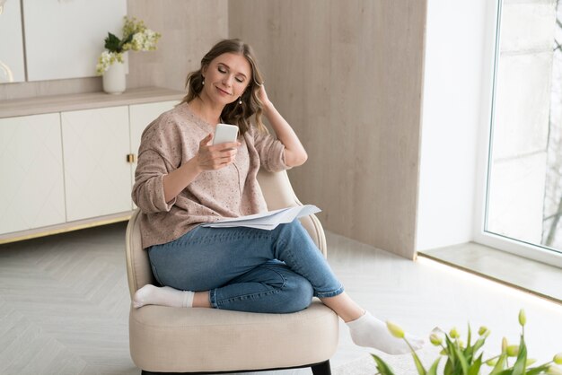 Full shot woman holding smartphone