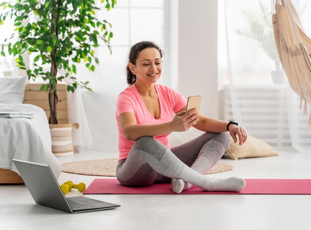 Full shot woman holding smartphone