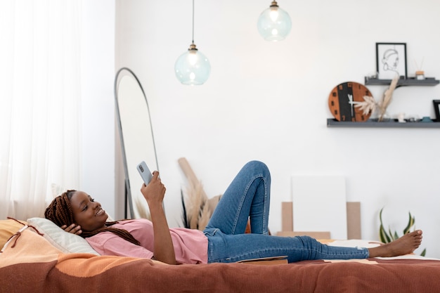 Full shot woman holding smartphone