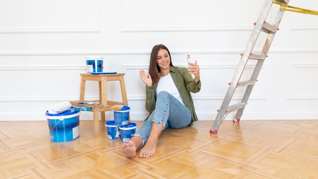 Full shot woman holding smartphone